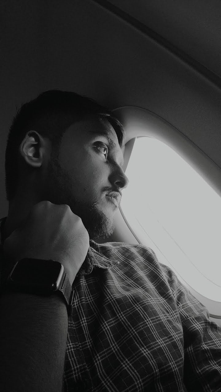 Black and white photo of Vishwas Jha looking out of an aeroplane window