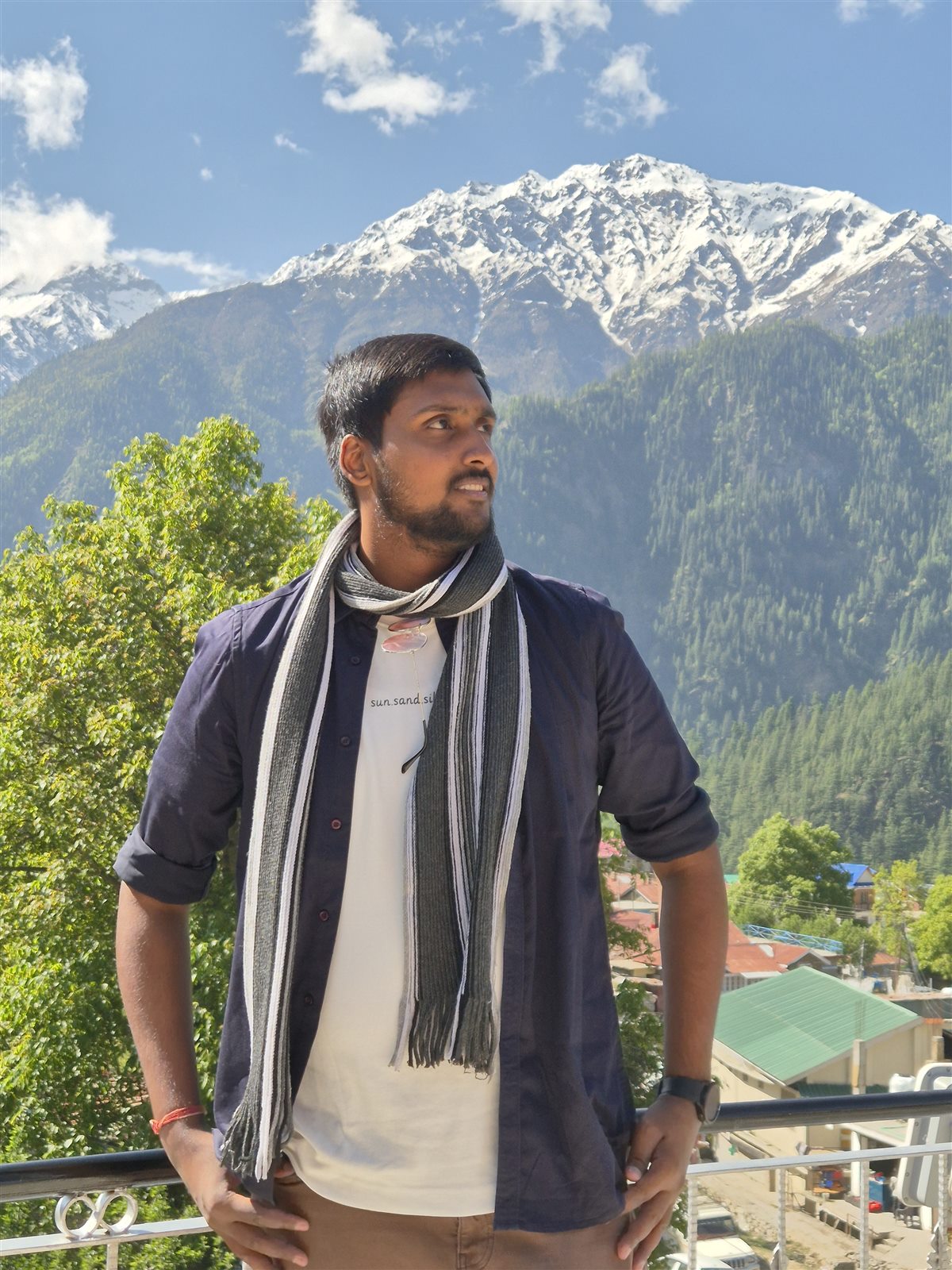 Vishwas Jha on a balcony with snow-capped Himalayan peaks behind him